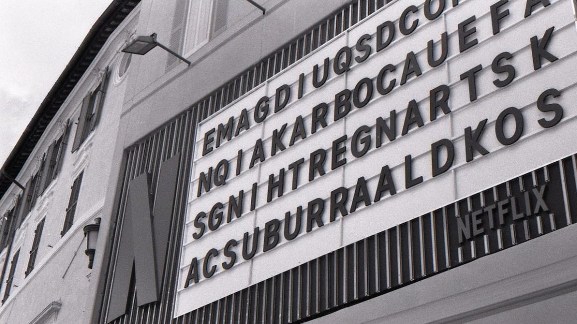 Monochrome building with a netflix sign and scrambled letters.
